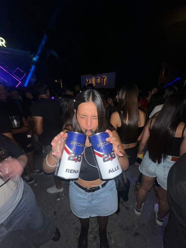 Egresada con dos vasos en el boliche